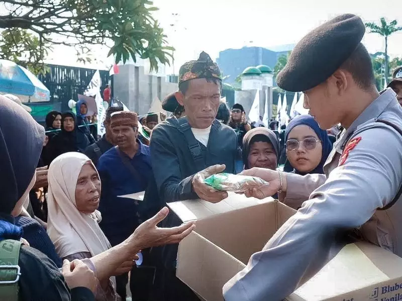 Polisi Berbagi Roti dan Air Mineral di Tengah Aksi Massa di DPR