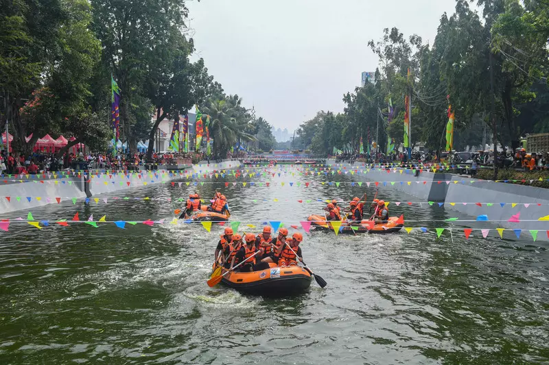 Foto: Adu Dayung Pakai Perahu Karet di Kali Ciliwung